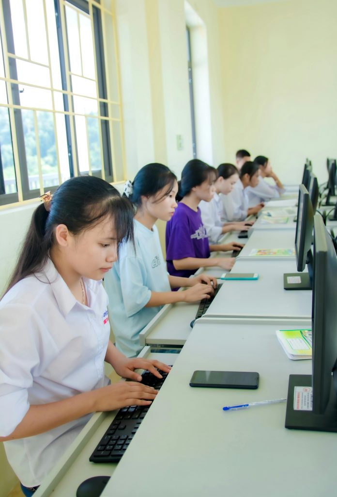 Young students engaged in a computer lab, focused on learning and collaboration.